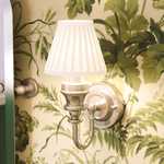 Vägglampa Burlington med vit finplisserad lampskärm och dekorativ bas Borstad nickel i badrum